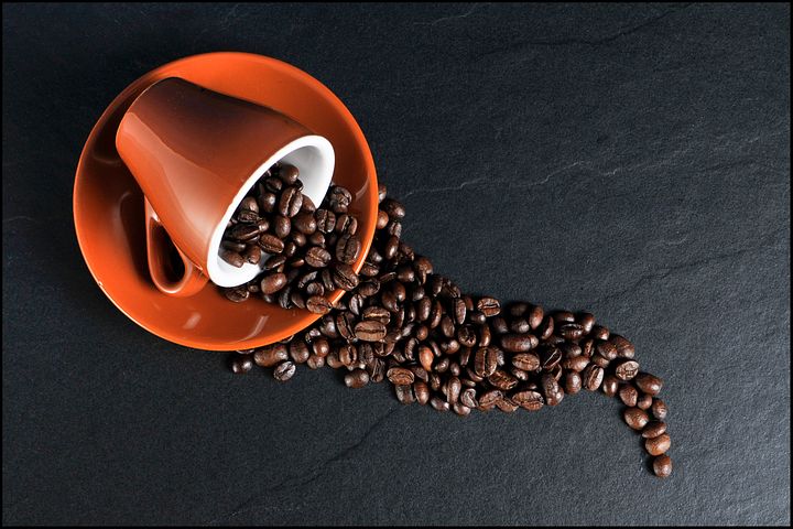 coffee beans on orange ceramic mug